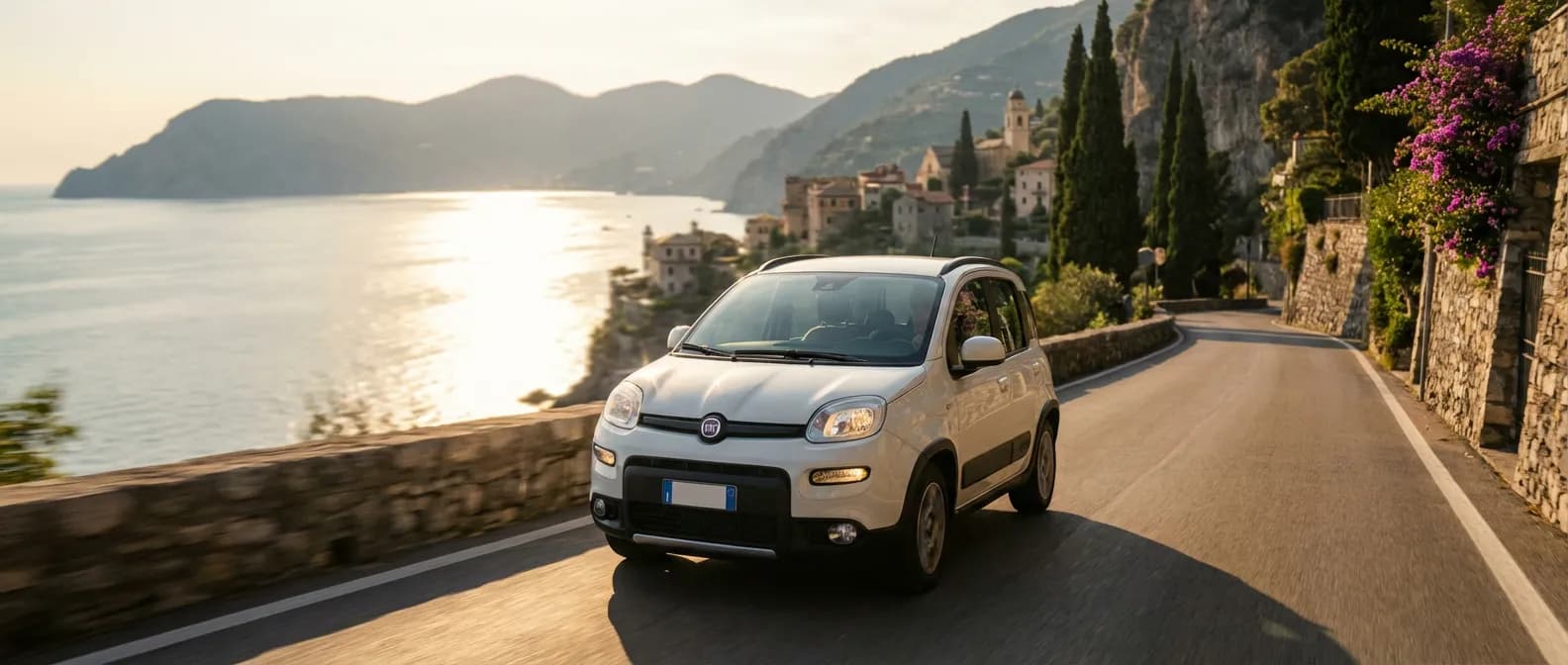 Une Fiat Panda 1.0 FireFly S&S Hybrid roulant sur une route côtière italienne au coucher du soleil.