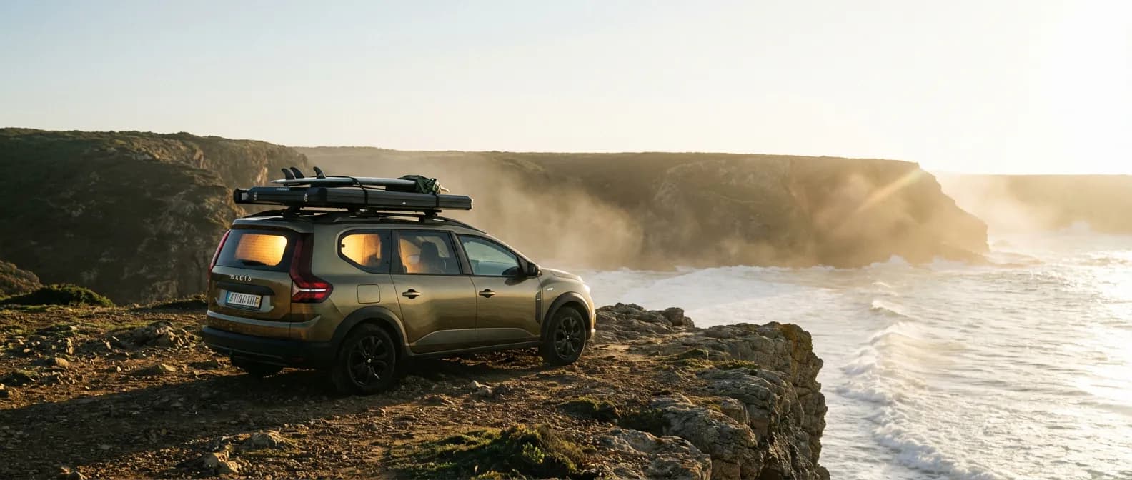 Dacia Jogger Camper : L'aventure en toute liberté Dacia Jogger aménagée en camping-car sur une falaise au coucher du soleil, style éditorial.