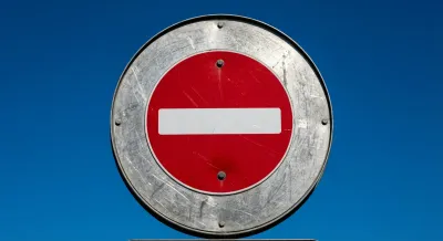 Panneau de signalisation sens interdit minimaliste sur fond de ciel bleu.