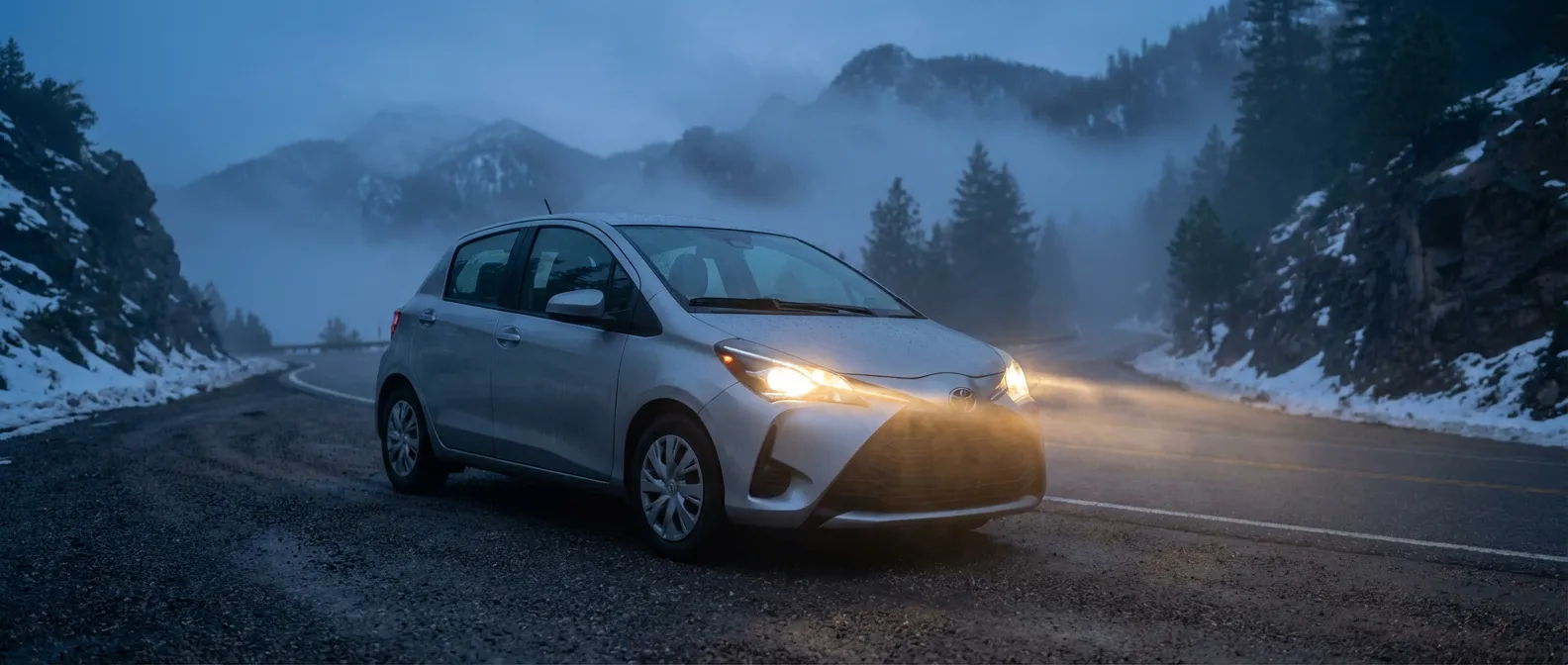 Analyse complète de la Toyota Yaris 1.4 D-4D Toyota Yaris 1.4 diesel sur une route de montagne brumeuse, style cinématographique haute résolution