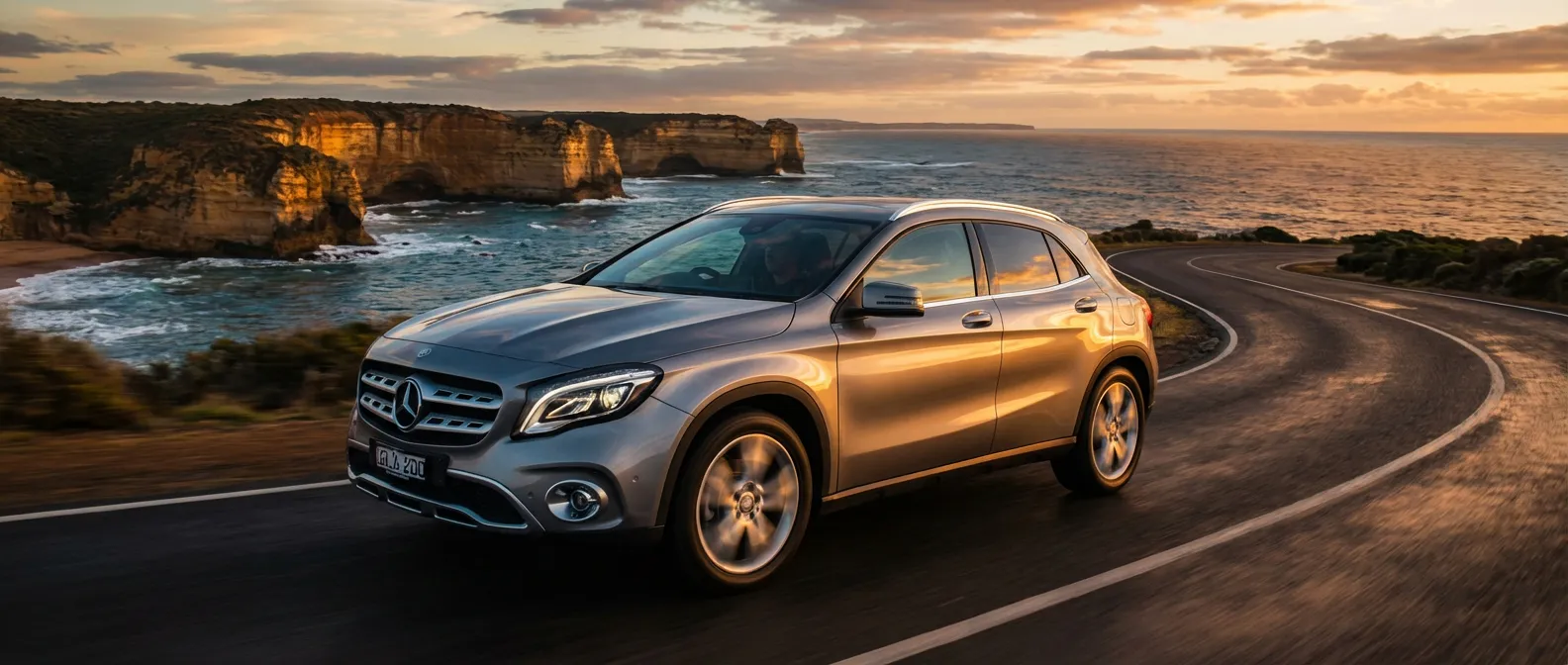 Mercedes-Benz GLA 200 d Executive roulant sur une route côtière au coucher du soleil