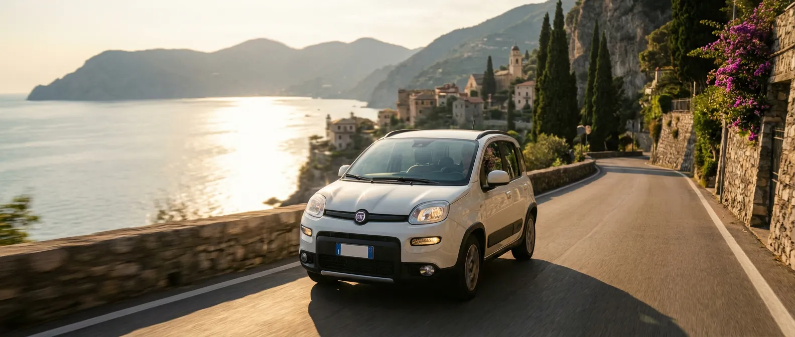 Une Fiat Panda 1.0 FireFly S&S Hybrid roulant sur une route côtière italienne au coucher du soleil.
